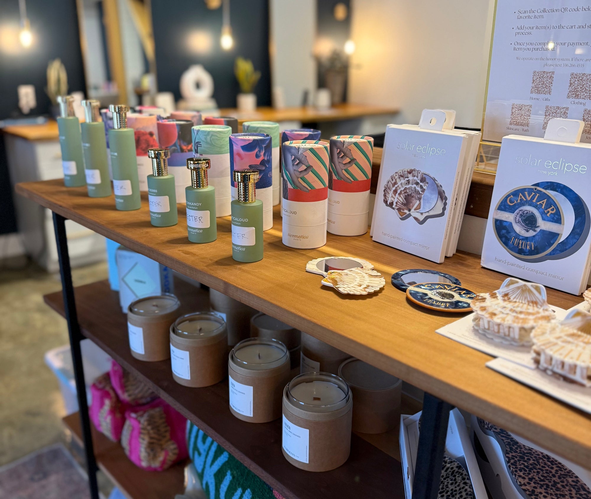 Display of candles and decorative items on a wooden shelf in a store.